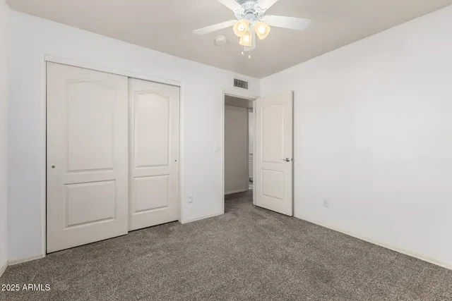 an empty room with a chandelier fan