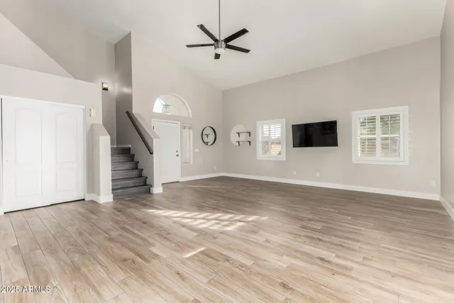 a view of a livingroom with wooden floor and a ceiling fan