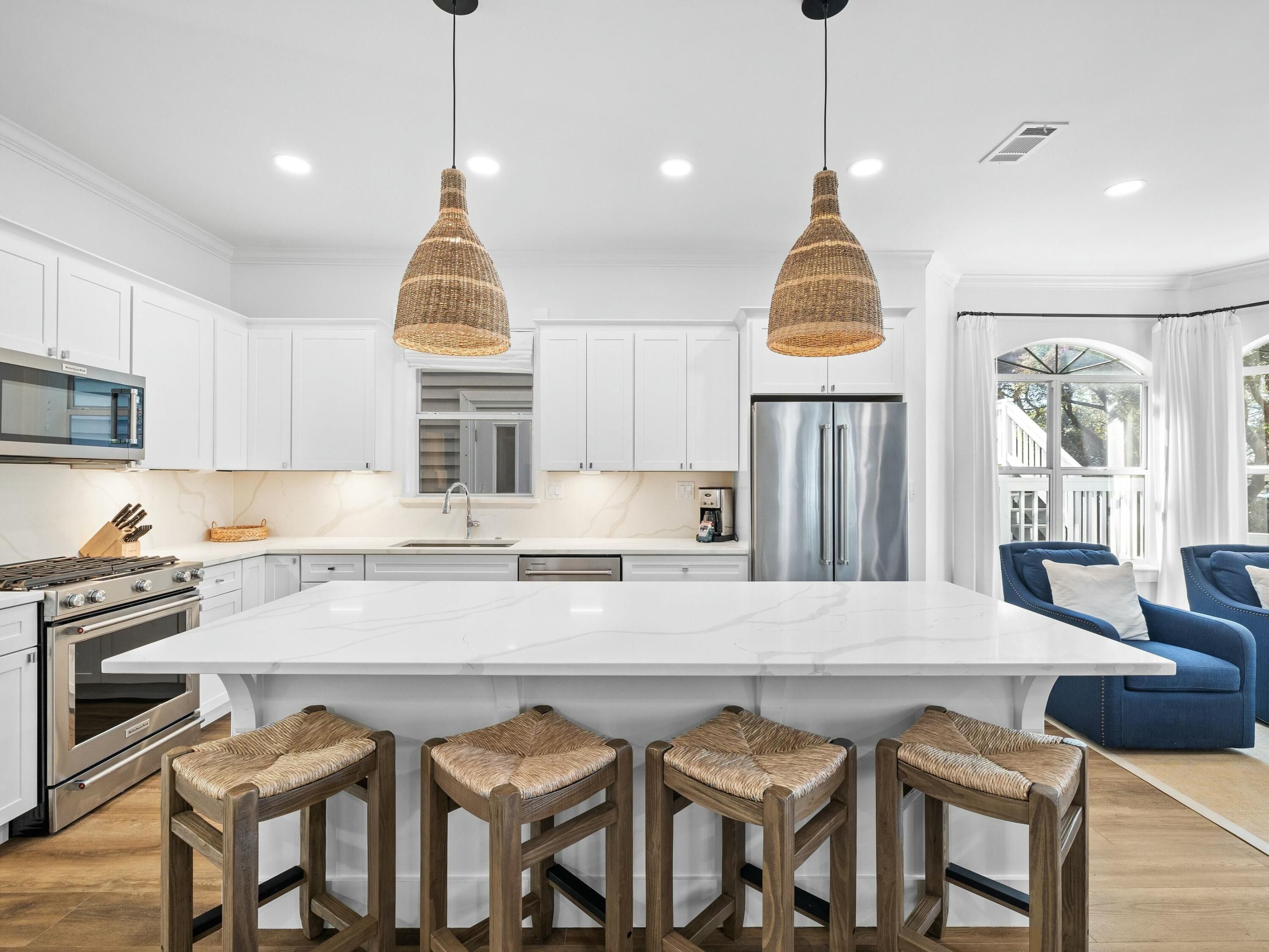 a kitchen with granite countertop a table chairs stove and refrigerator