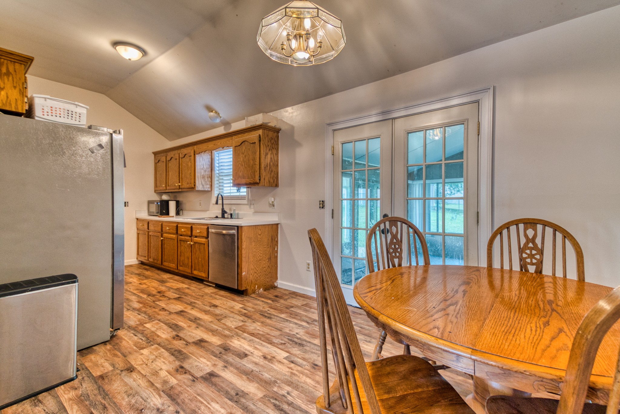 190 Rose Street Greenbrier, TN 37073 - Photo 21 of 32 a dining room with stainless steel appliances a table chairs a refrigerator and chandelier
