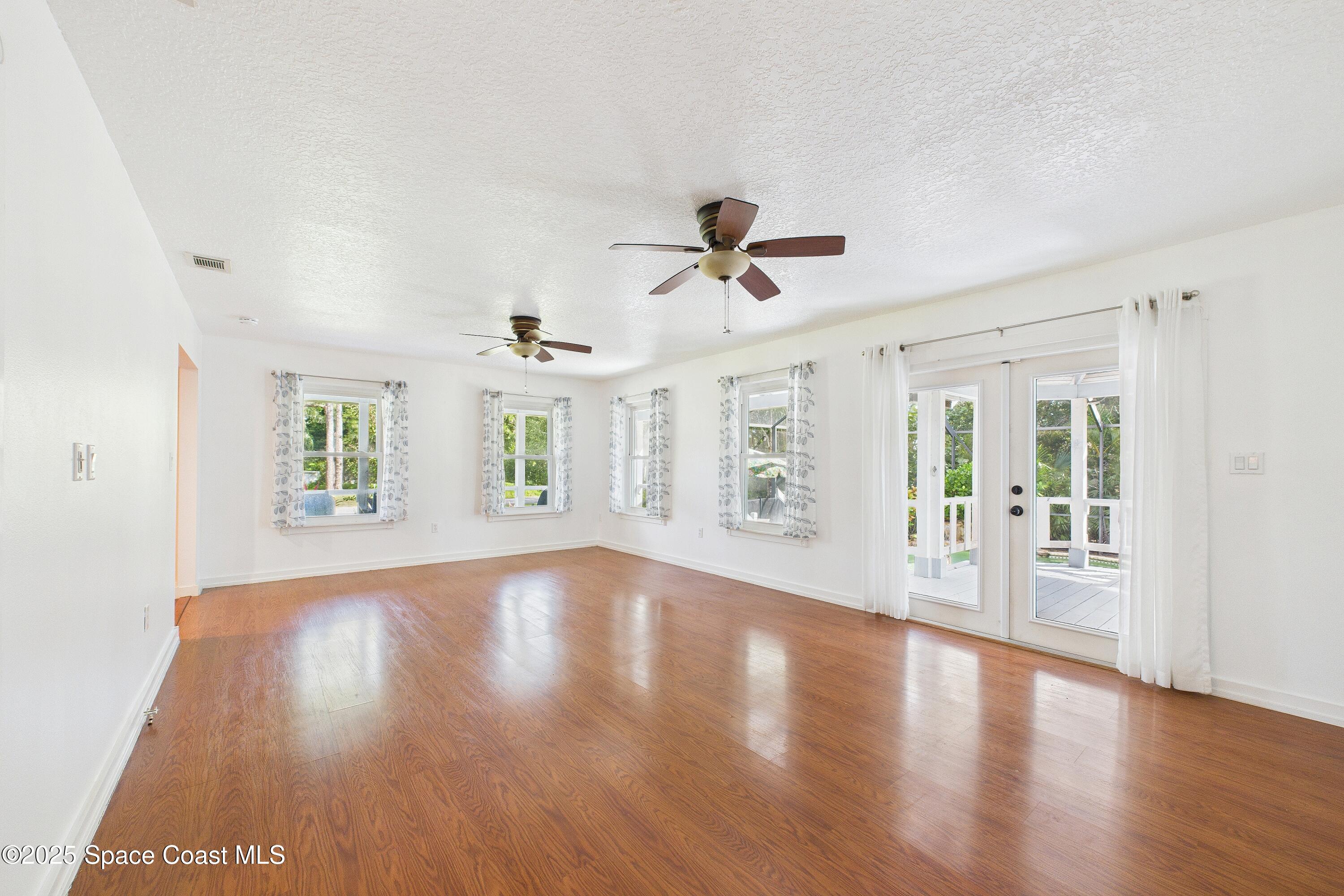 3435 Huggins Drive Malabar, FL 32950 - Photo 14 of 63 a view of an empty room with wooden floor and a window