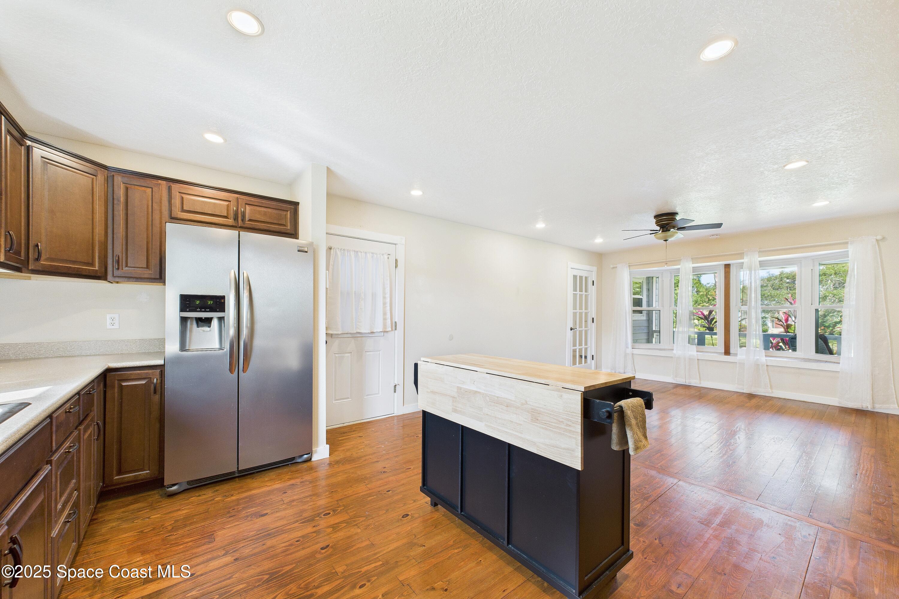 3435 Huggins Drive Malabar, FL 32950 - Photo 23 of 63 a kitchen with stainless steel appliances granite countertop a refrigerator a sink and wooden floors