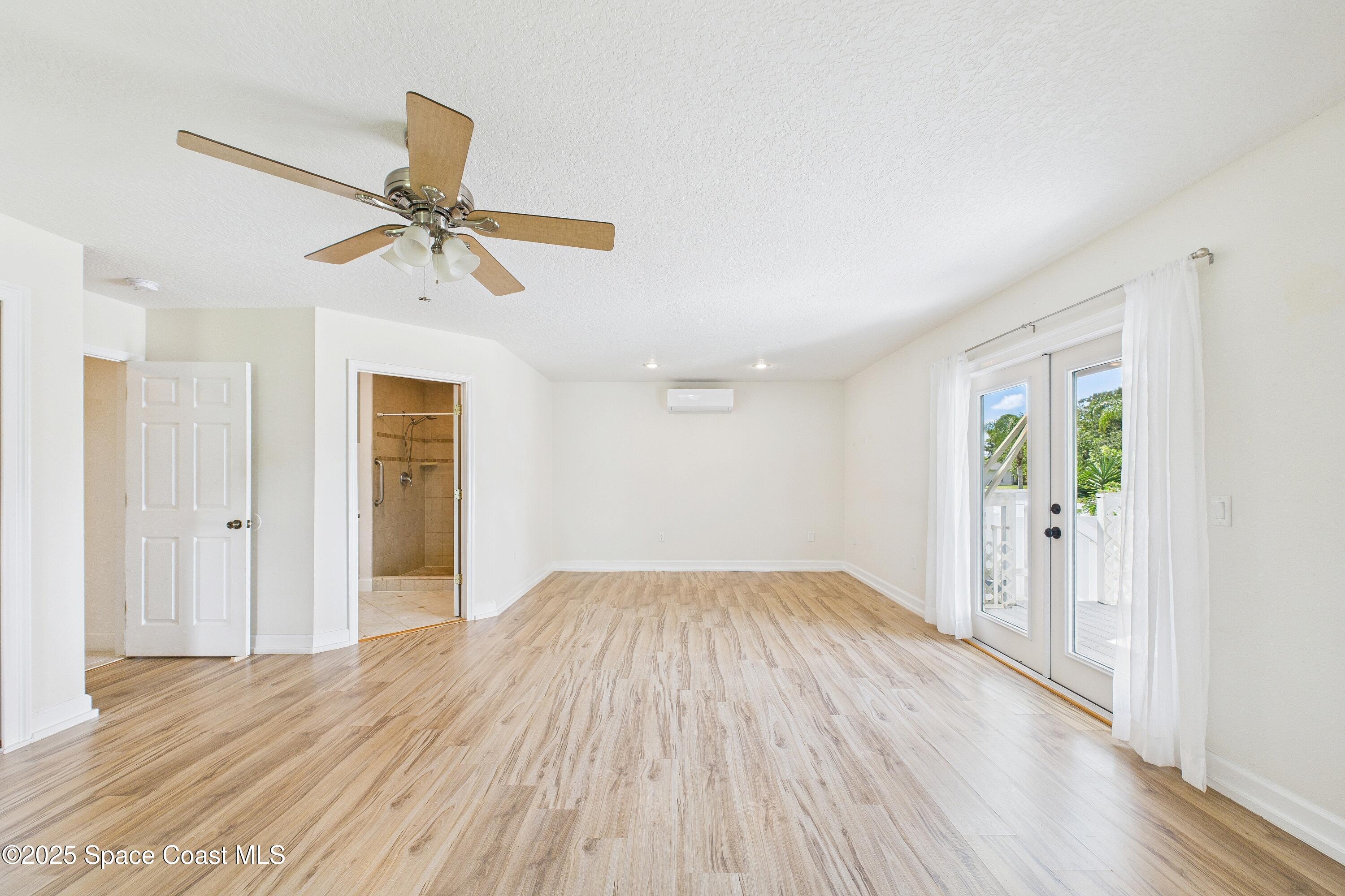 3435 Huggins Drive Malabar, FL 32950 - Photo 29 of 63 an empty room with wooden floor fan and windows