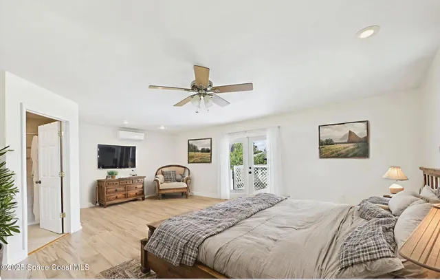 a bedroom with a bed chandelier and a window