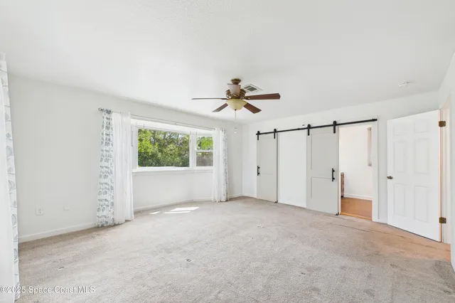 an empty room with a window and a fan