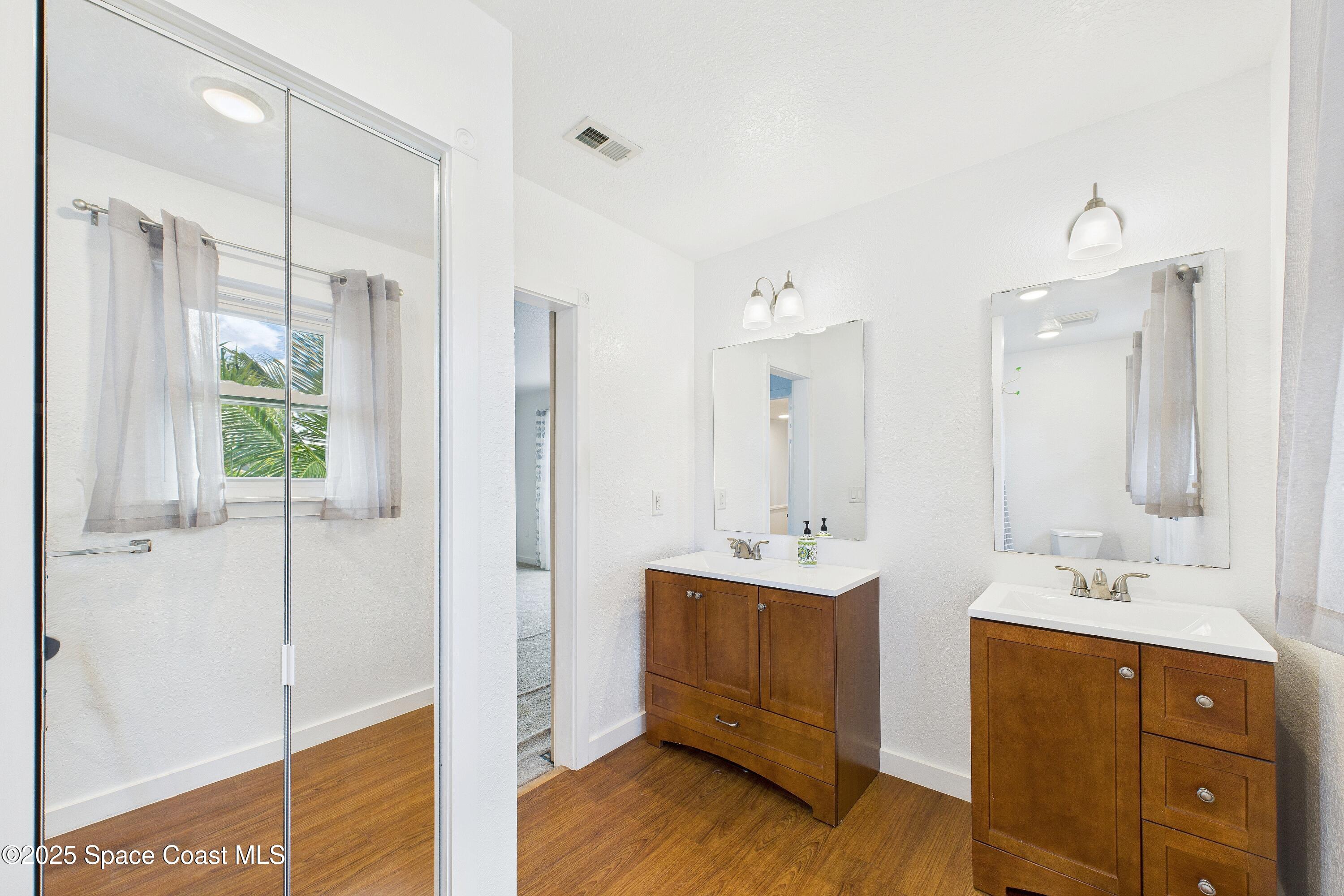 3435 Huggins Drive Malabar, FL 32950 - Photo 42 of 63 a bathroom with a double vanity sink a mirror and a shower