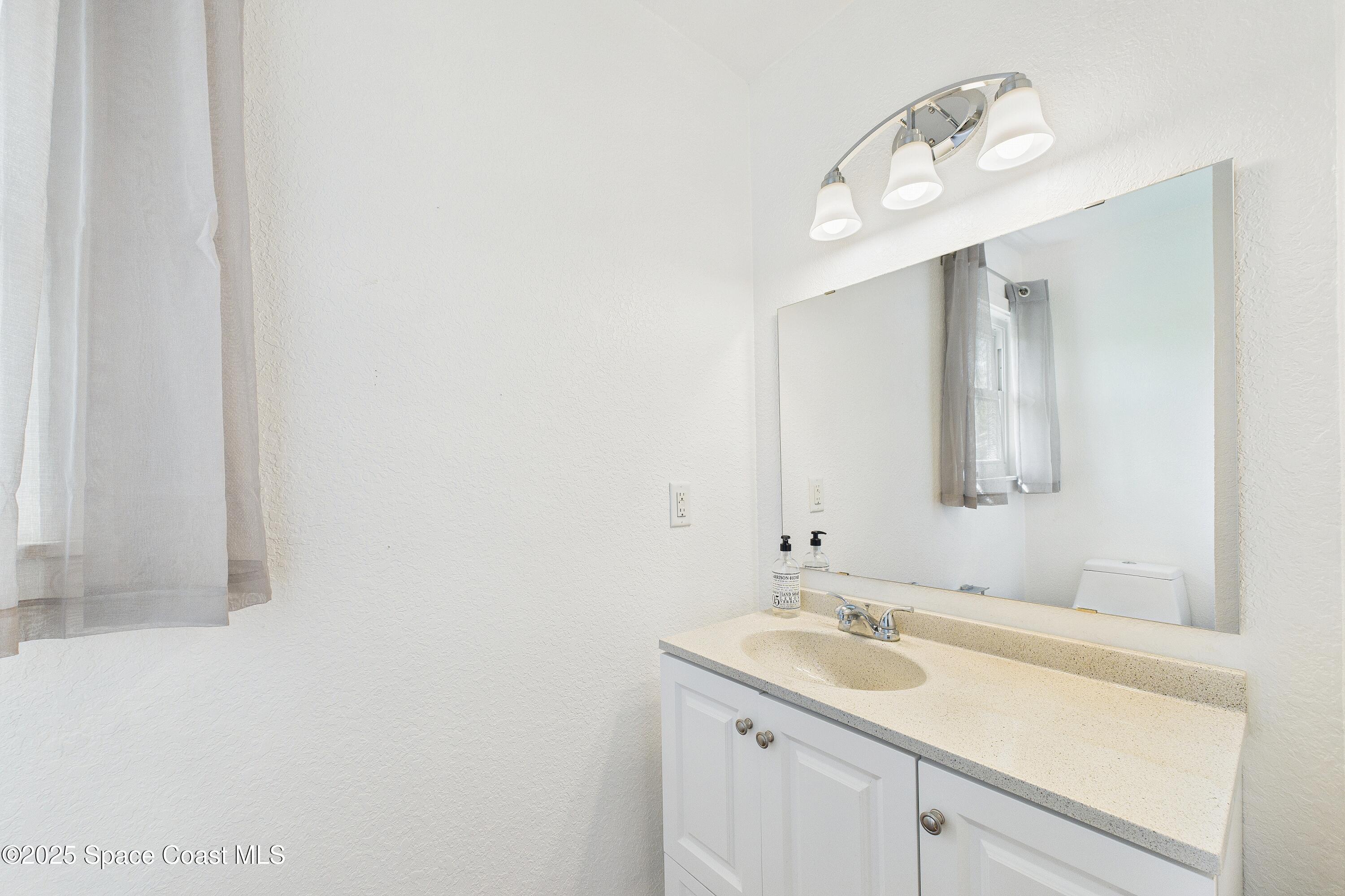 3435 Huggins Drive Malabar, FL 32950 - Photo 51 of 63 a bathroom with a sink and a mirror