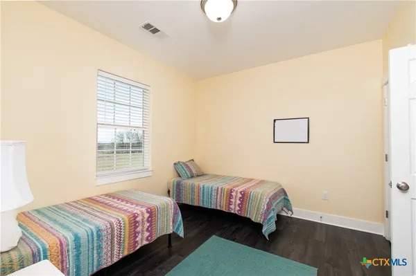 a bedroom with two beds and a potted plant
