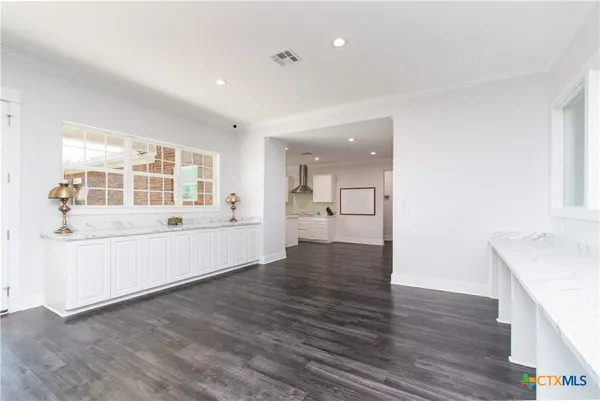 a kitchen with stove cabinets and wooden floor