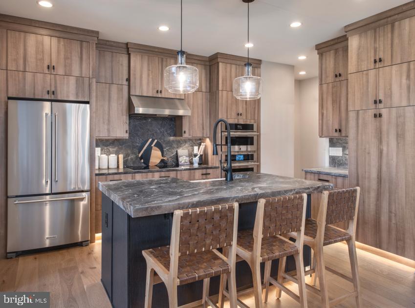 508 Trifecta Road, Unit 275 Downingtown, PA 19335 - Photo 39 of 44 a kitchen with stainless steel appliances granite countertop a table chairs refrigerator and microwave