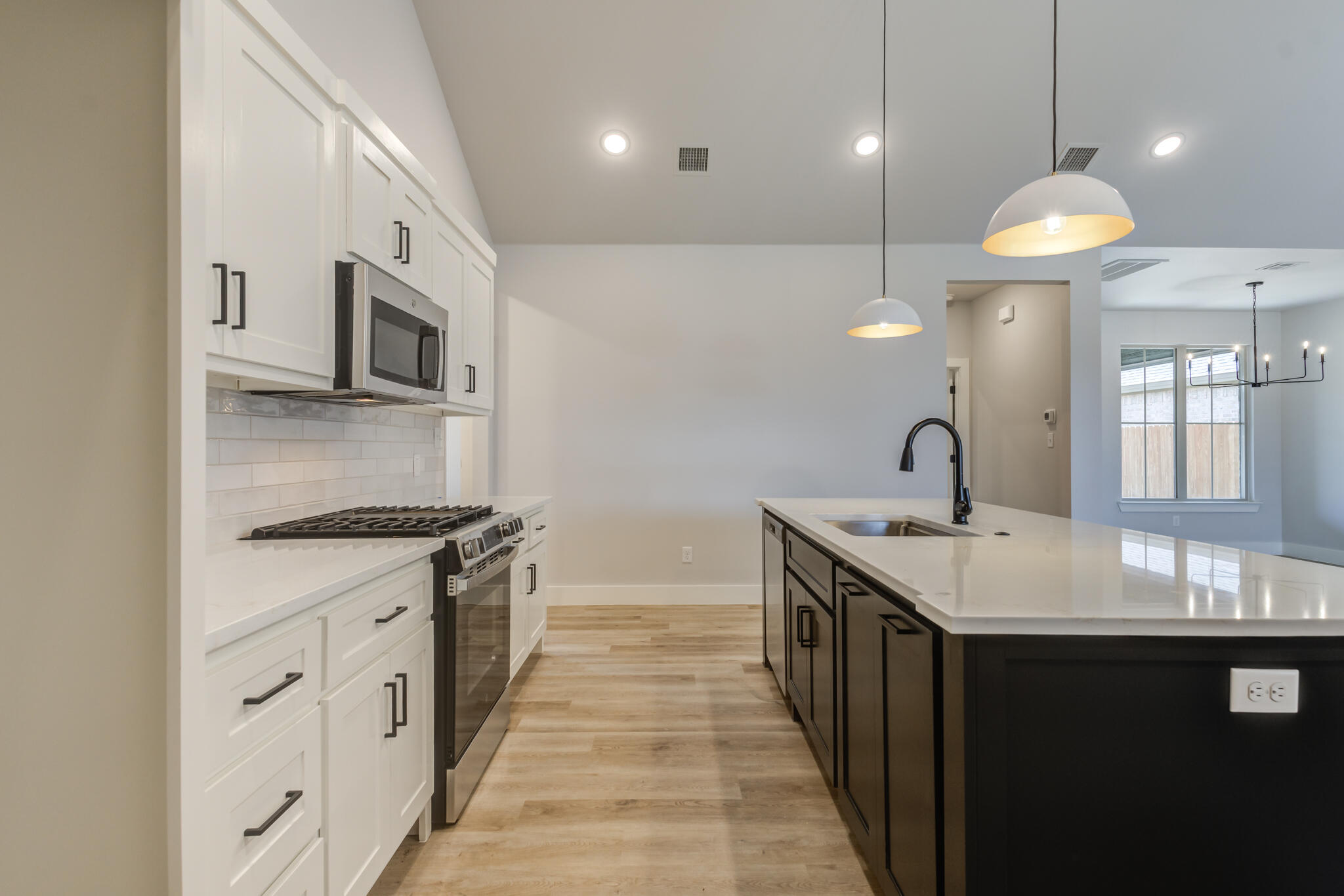 6914 13th Street Lubbock, TX 79416 - Photo 23 of 49 a kitchen with stainless steel appliances granite countertop a sink a stove and a wooden floors