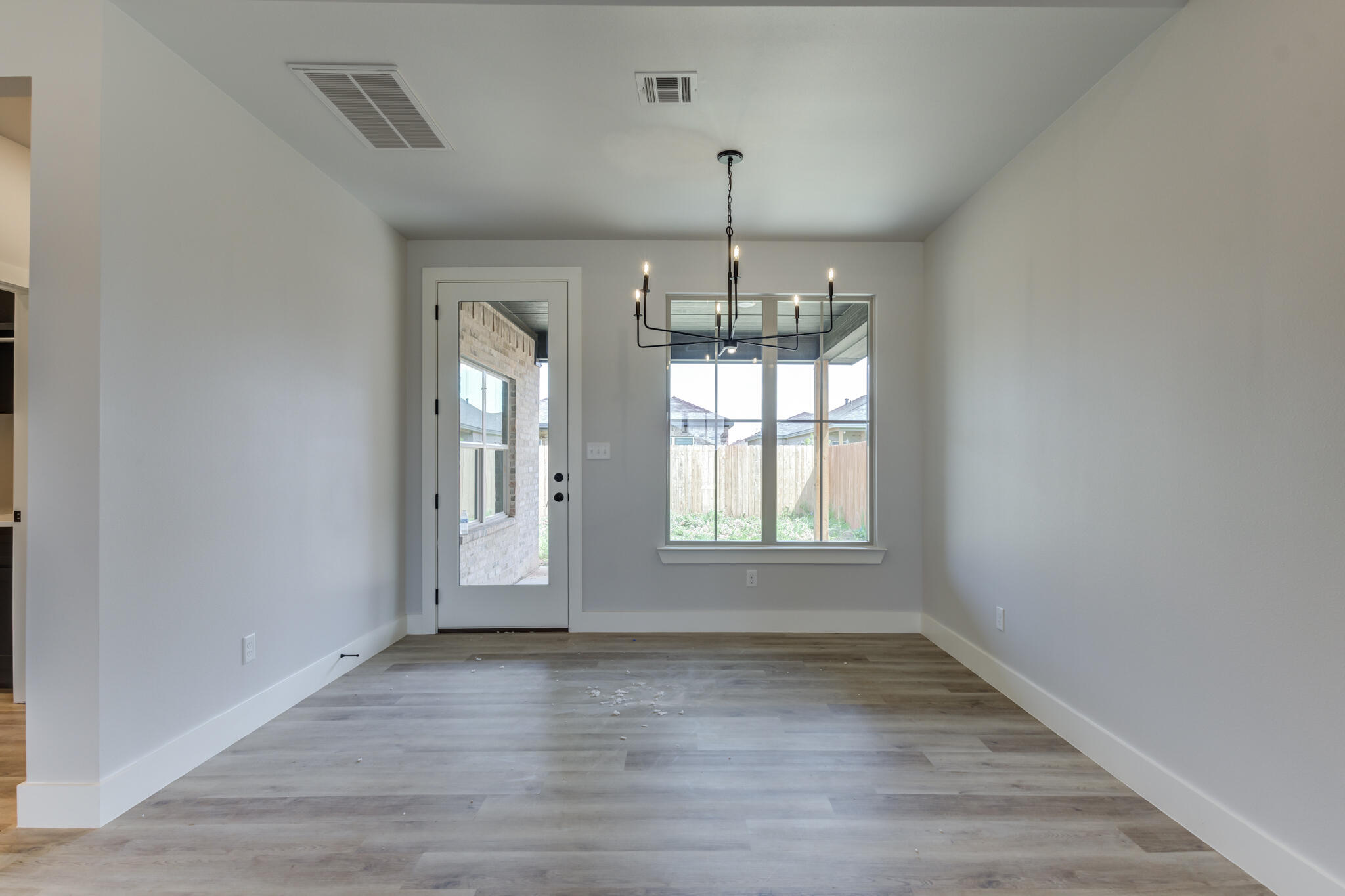 6914 13th Street Lubbock, TX 79416 - Photo 29 of 49 an empty room with wooden floor and chandelier