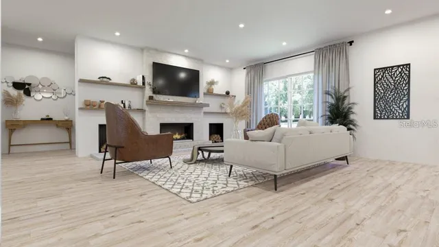 a living room with furniture a flat screen tv and kitchen view