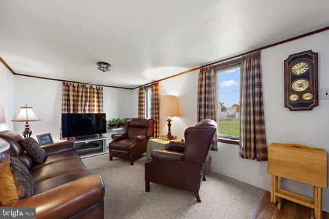 a living room with furniture a flat screen tv and a window