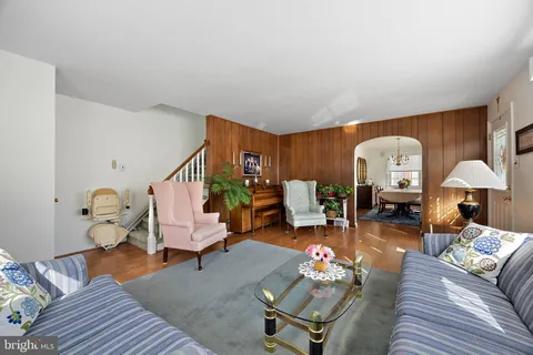 a living room with furniture and a chandelier