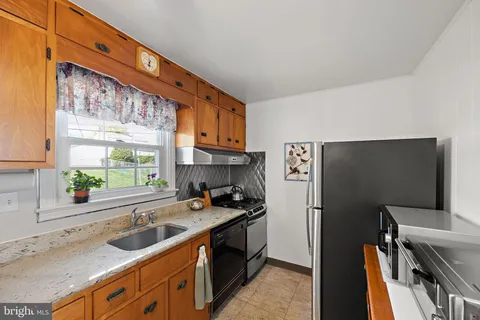 a kitchen with stainless steel appliances a sink a stove and a refrigerator