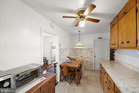 a kitchen with stainless steel appliances granite countertop a stove oven a dining table and chairs with wooden floor