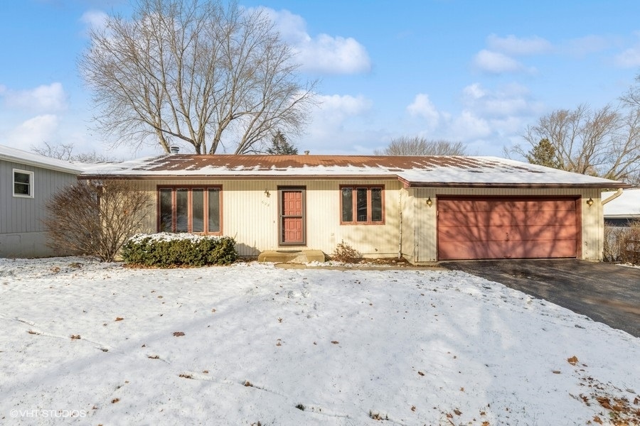 628 West Main Street Cary, IL 60013 - Photo 1 of 20 a front view of a house with a dirt yard and a large tree