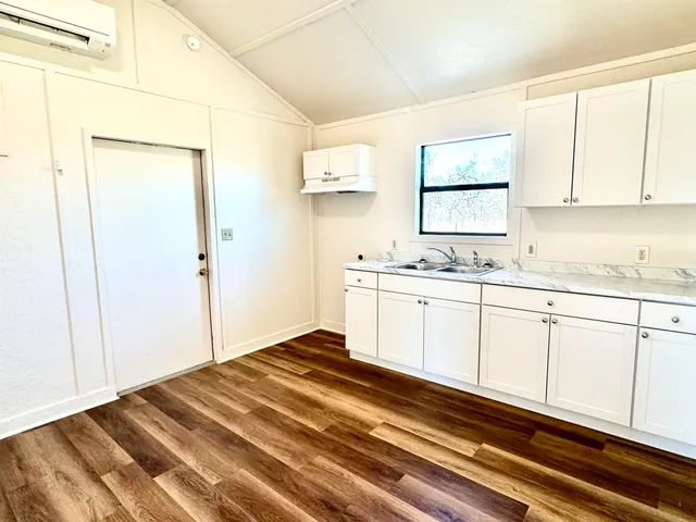 a kitchen with granite countertop white cabinets and white appliances