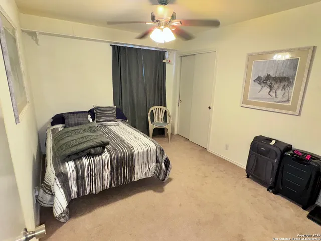 a bedroom with a bed and a ceiling fan