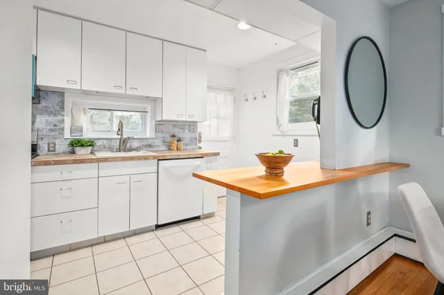 a kitchen with stainless steel appliances kitchen island granite countertop a sink a stove and white cabinets