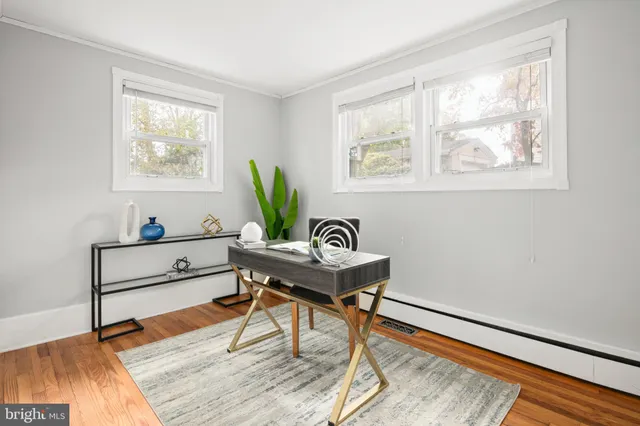 a view of a workspace with furniture and wooden floor