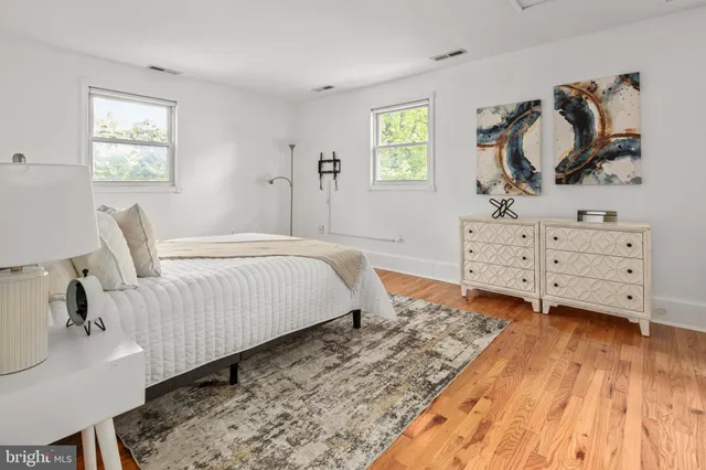 a view of a bedroom with wooden floor and cabinet