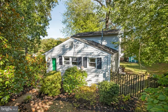 a front view of house with yard and trees around