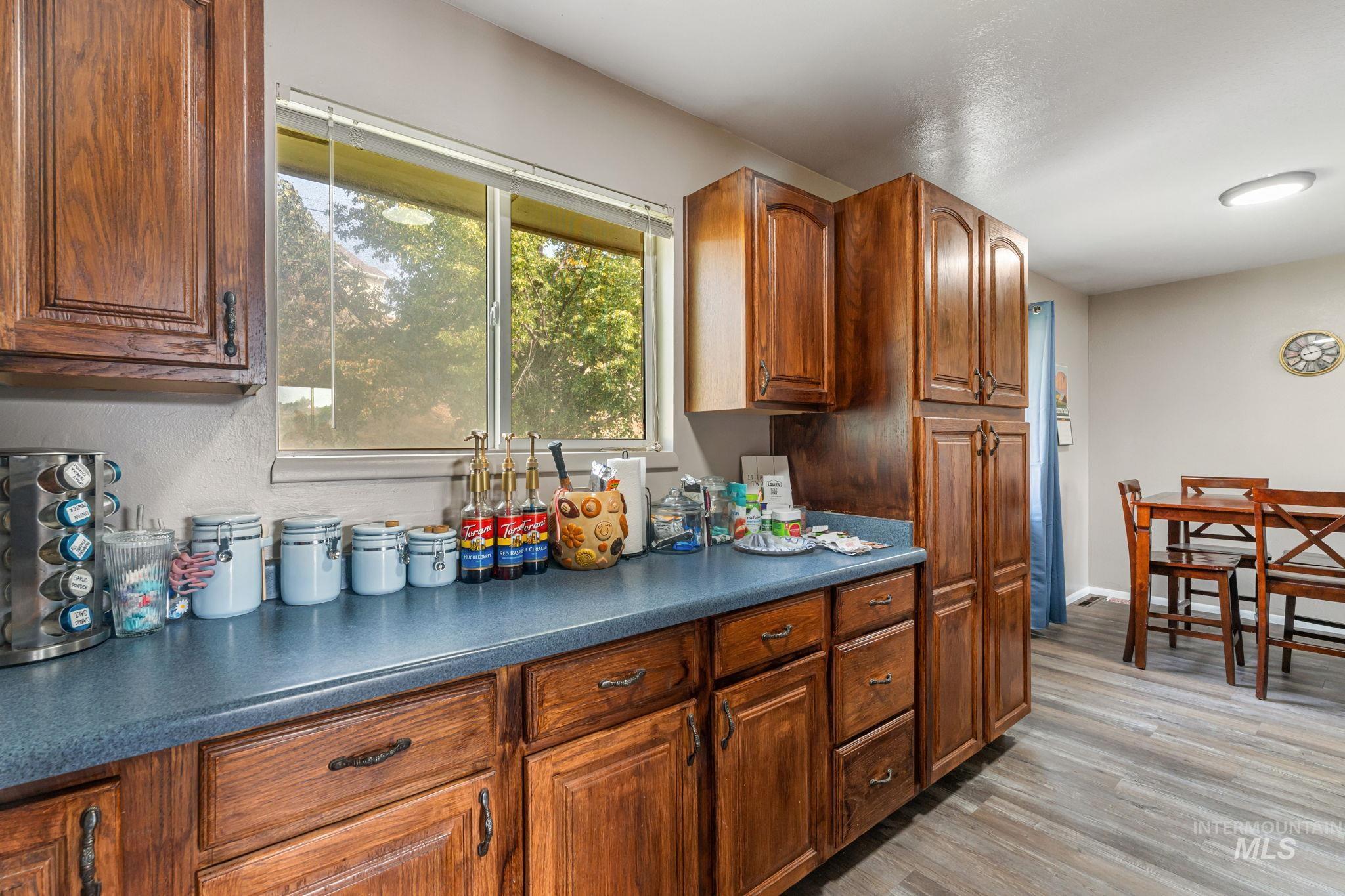 816 Park Lane Pocatello, ID 83201 - Photo 11 of 48 Kitchen with dark countertops, light wood-style flooring, and brown cabinetry