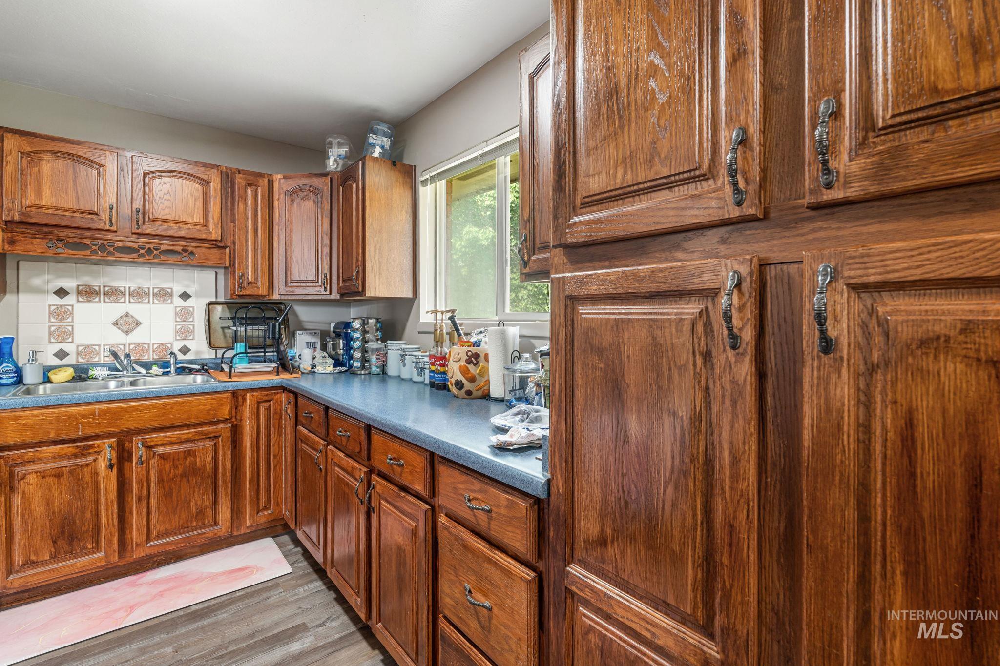 816 Park Lane Pocatello, ID 83201 - Photo 13 of 48 Kitchen with brown cabinetry, dark countertops, and light wood-type flooring