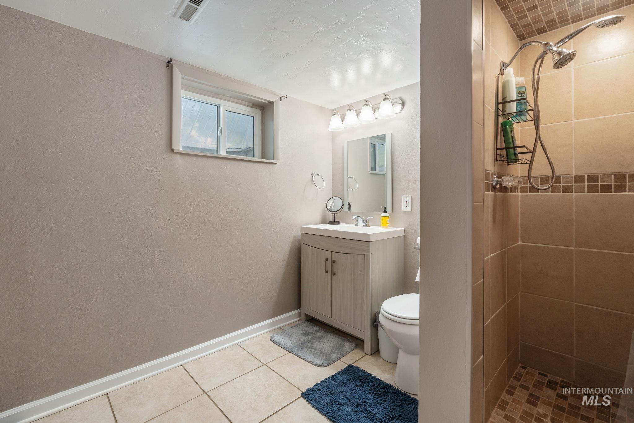 816 Park Lane Pocatello, ID 83201 - Photo 31 of 48 Full bathroom with a shower stall, vanity, and light tile patterned flooring
