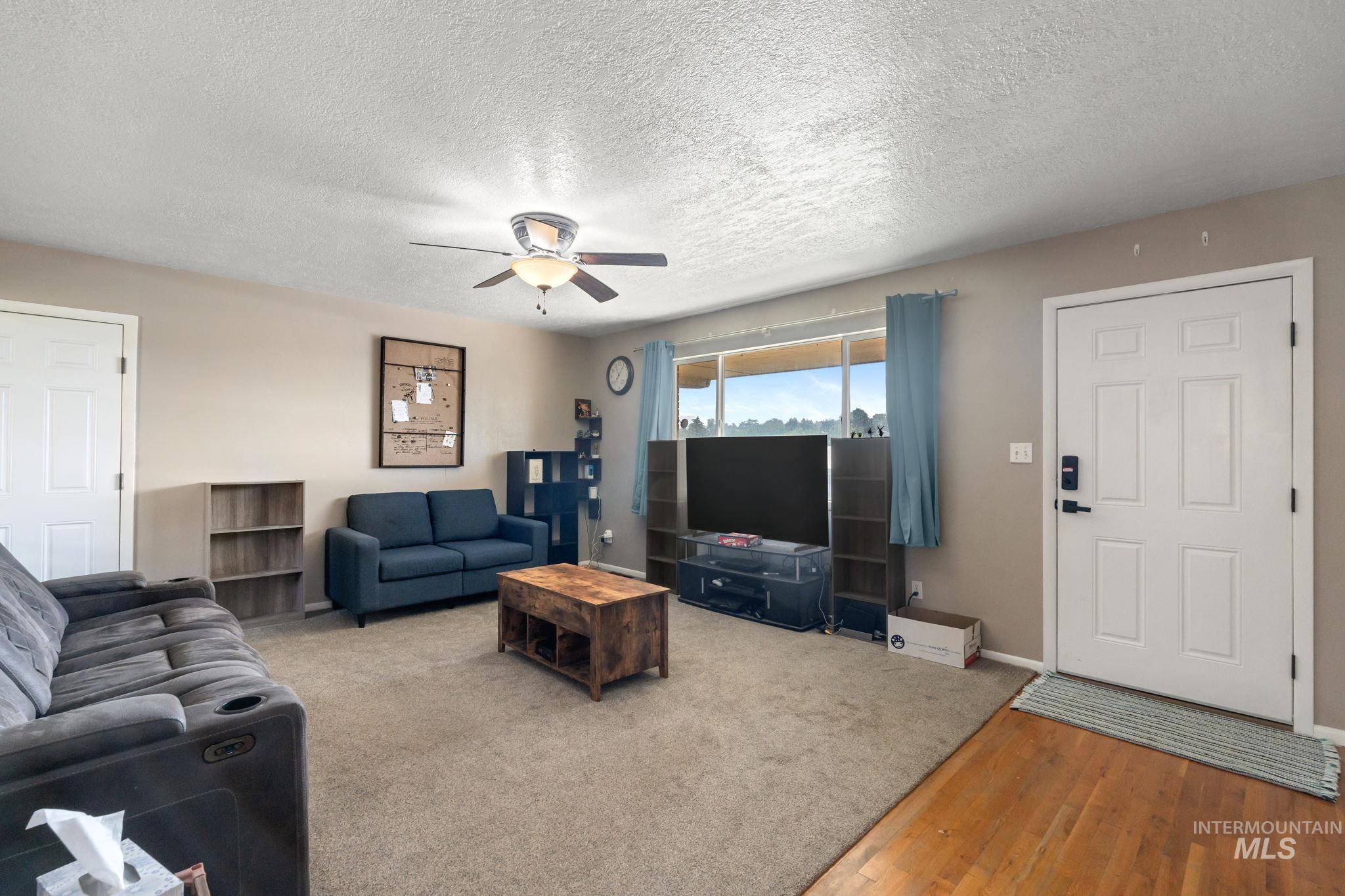 816 Park Lane Pocatello, ID 83201 - Photo 7 of 48 Living area with a textured ceiling, wood finished floors, and a ceiling fan
