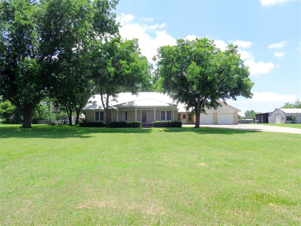 1717 Pipeline Road Cleburne, TX 76033 - Photo 23 of 33 Expansive green lawn surrounds a single-story residence with a metal roof and light-colored brick exterior