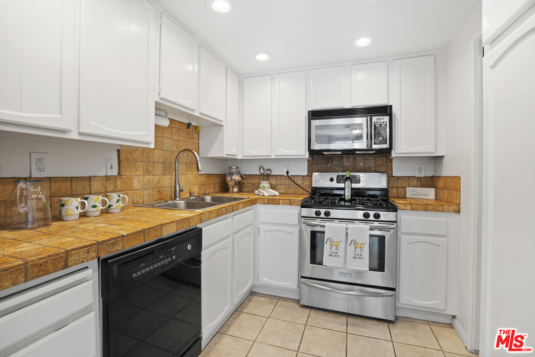 8135 Redlands Street, Unit 101 Playa del Rey, CA 90293 - Photo 11 of 42 a kitchen with stainless steel appliances granite countertop a stove a sink and a microwave
