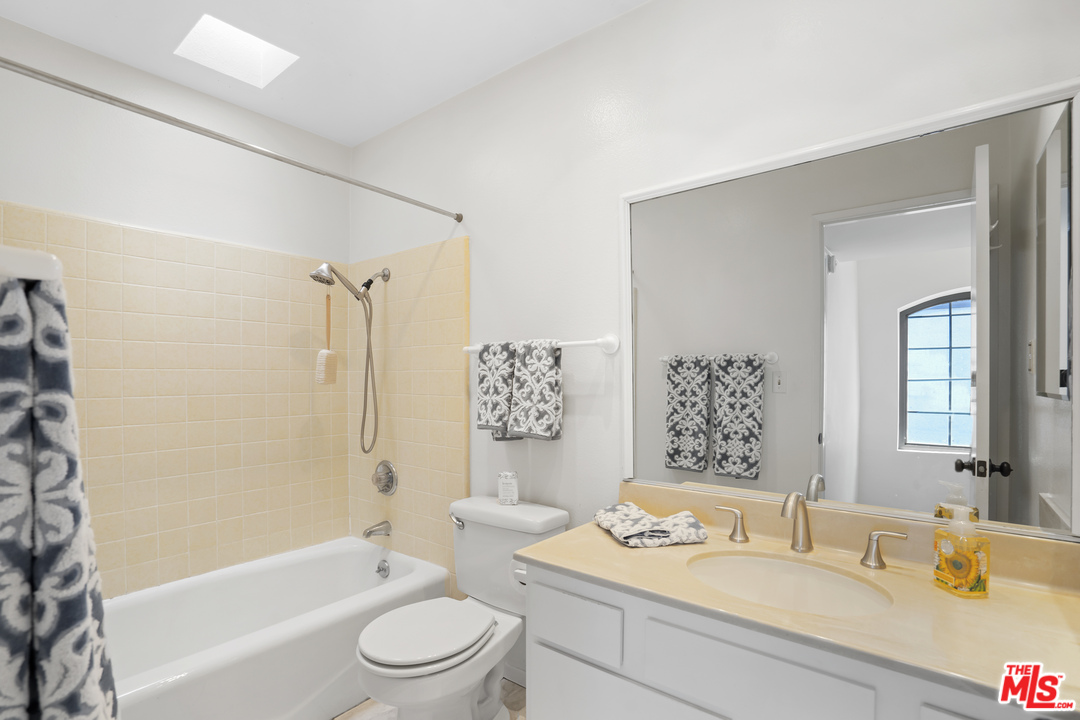8135 Redlands Street, Unit 101 Playa del Rey, CA 90293 - Photo 35 of 42 a bathroom with a granite countertop sink toilet a mirror a bathtub and shower