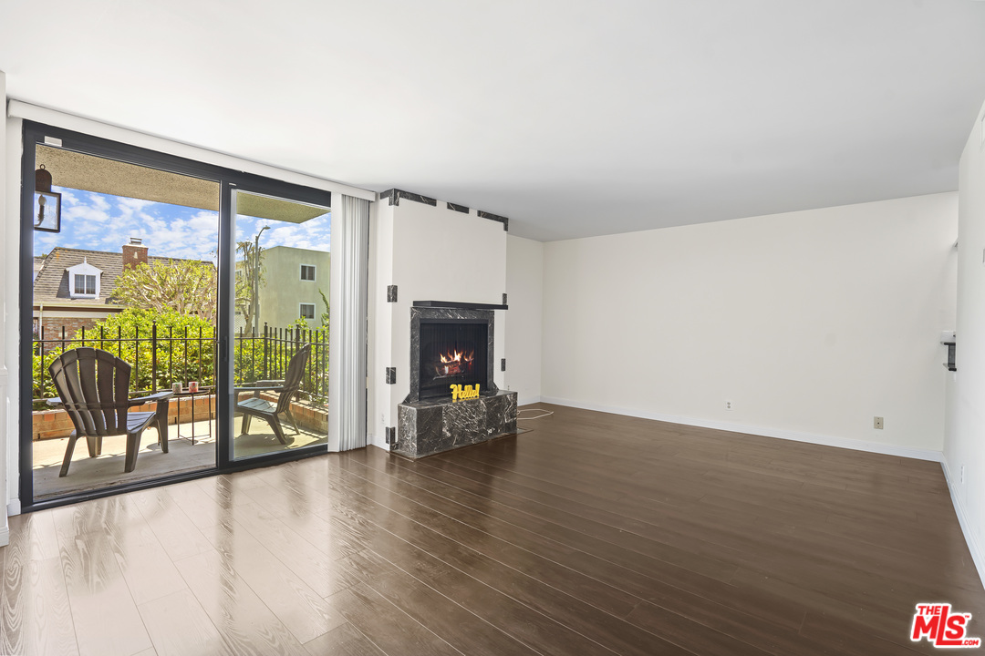 8135 Redlands Street, Unit 101 Playa del Rey, CA 90293 - Photo 8 of 42 a view of empty room with wooden floor and fireplace
