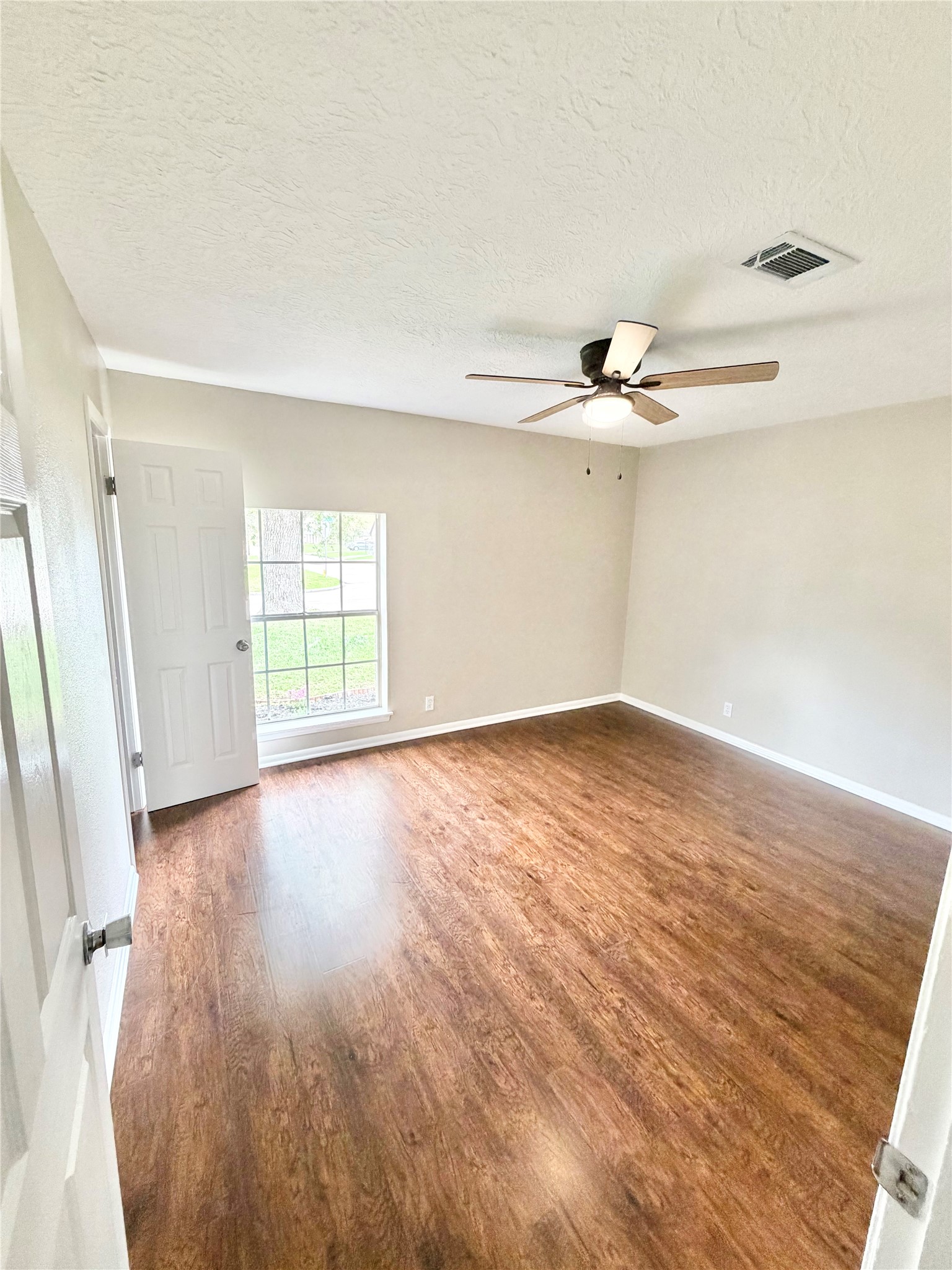 98 Sparrow Way Beaumont, TX 77707 - Photo 14 of 25 wooden floor in an empty room with a window