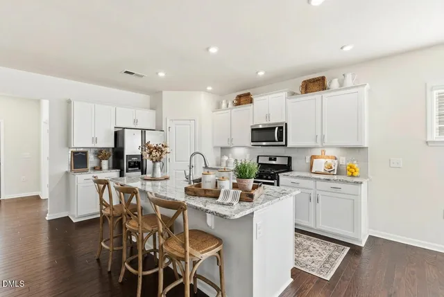 a kitchen with a stove a sink and a wooden floor