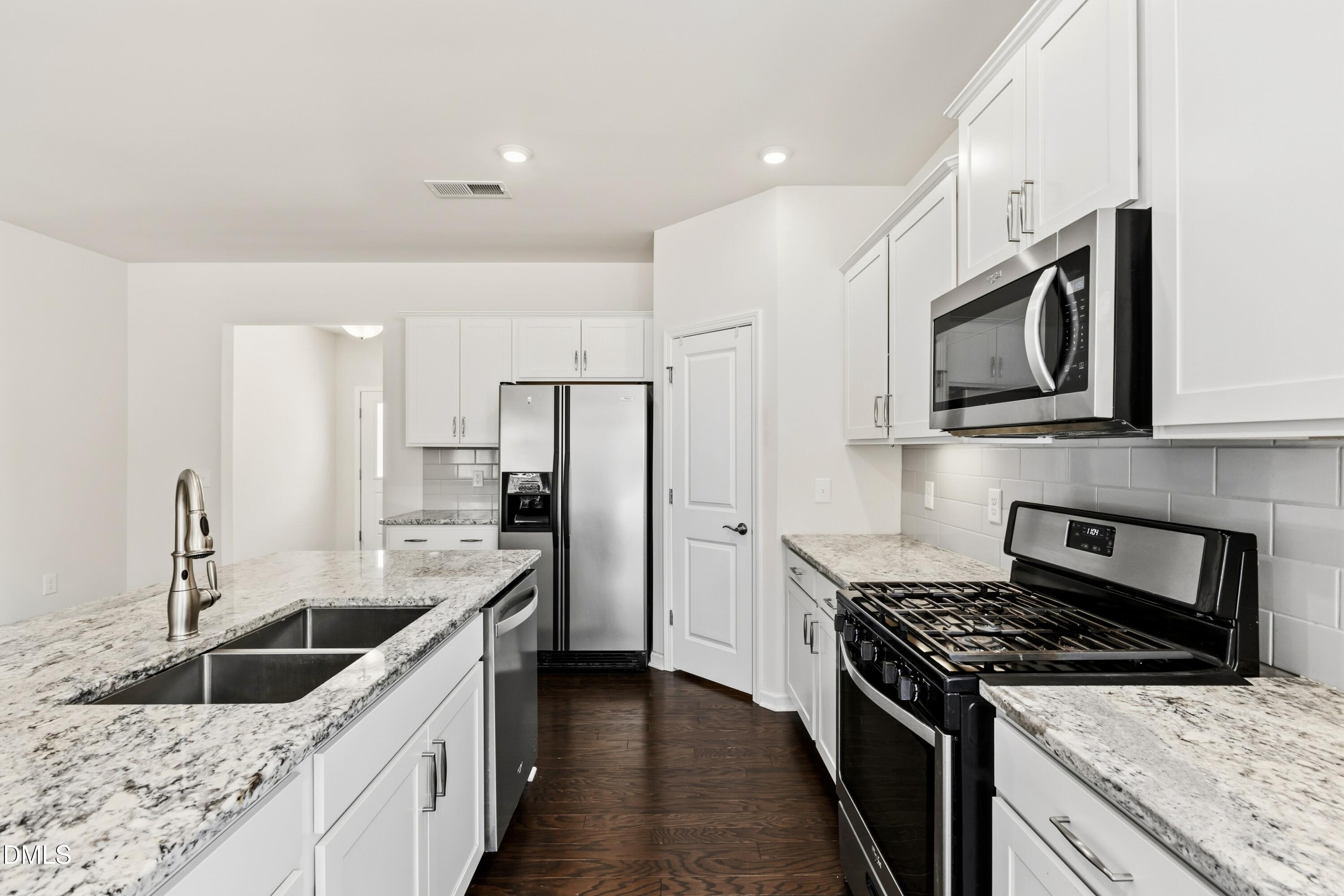 1018 Flyfish Avenue Durham, NC 27703 - Photo 16 of 54 a kitchen with stainless steel appliances granite countertop a sink stove and refrigerator