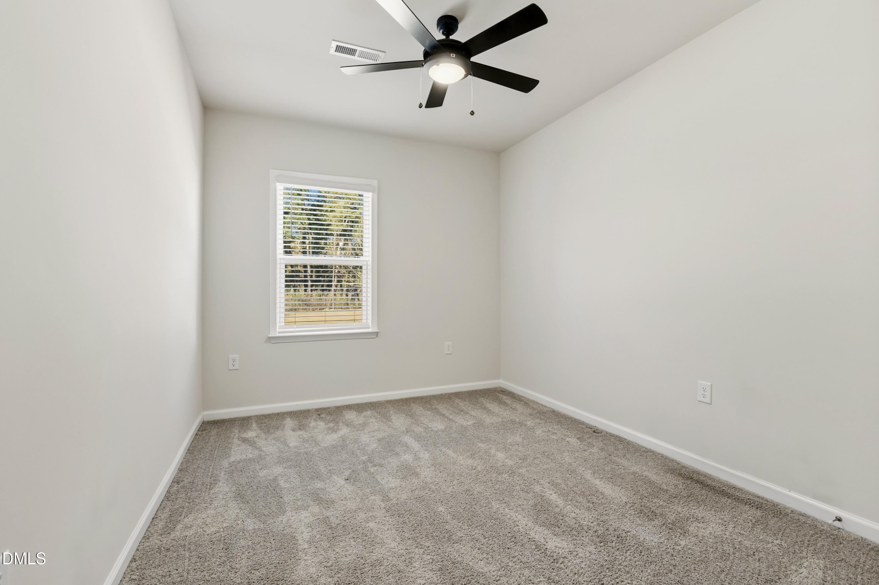 1018 Flyfish Avenue Durham, NC 27703 - Photo 28 of 54 an empty room with a window and a fan