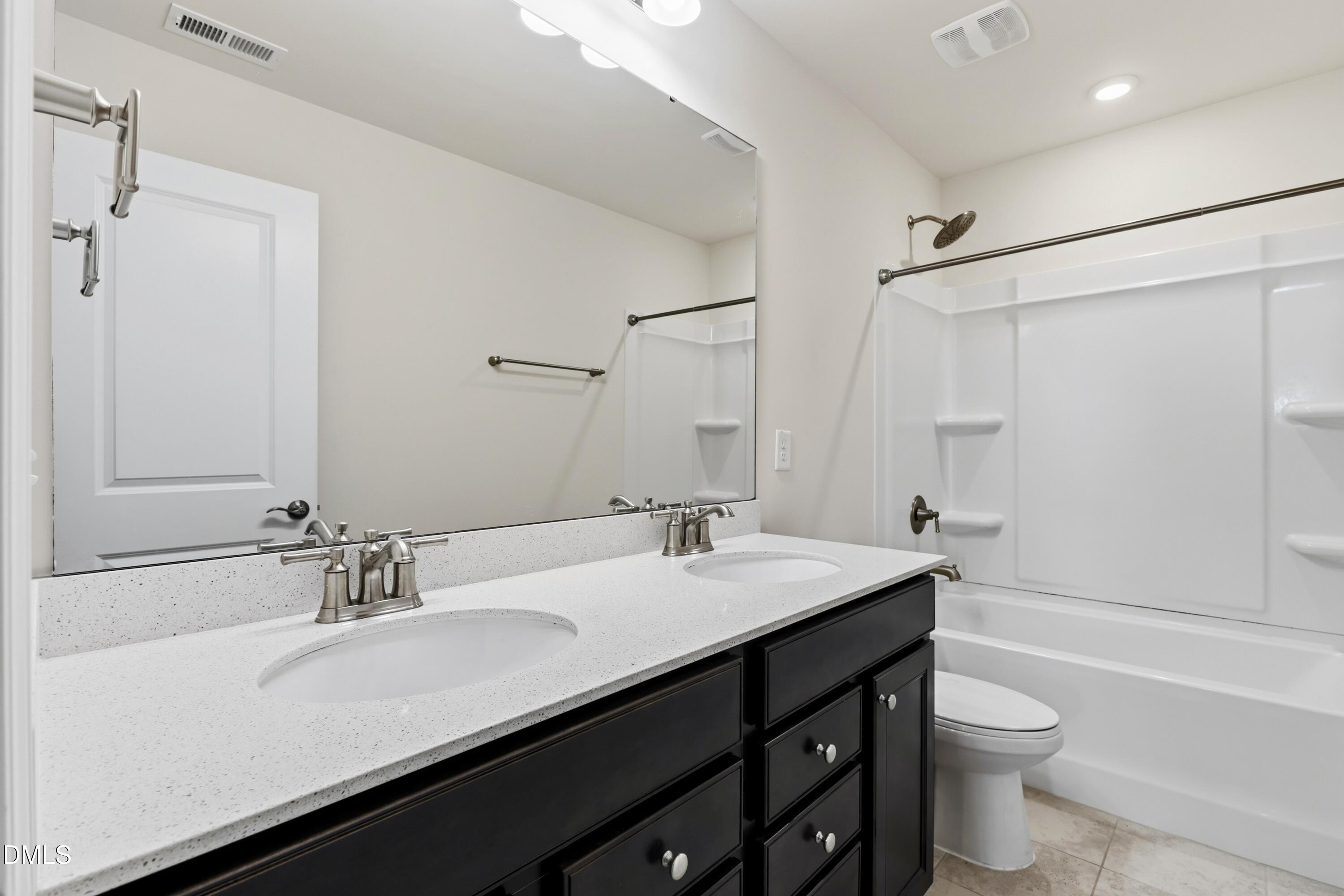 1018 Flyfish Avenue Durham, NC 27703 - Photo 44 of 54 a bathroom with a double vanity sink toilet and shower