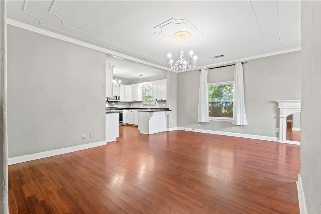 4073 Cedar Street Riverside, CA 92501 - Photo 13 of 46 an empty room with wooden floor kitchen view and windows