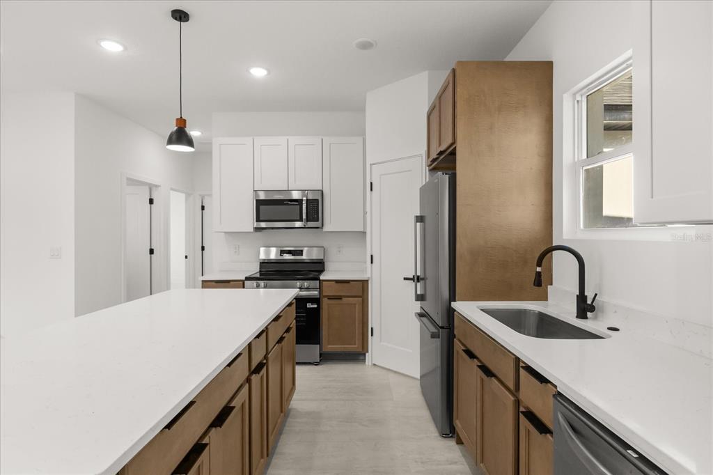6168 Southwest 154th Street Ocala, FL 34473 - Photo 15 of 33 a kitchen with a sink a counter top space stainless steel appliances and cabinets