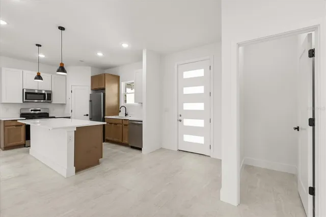 a kitchen with kitchen island a sink stainless steel appliances and window