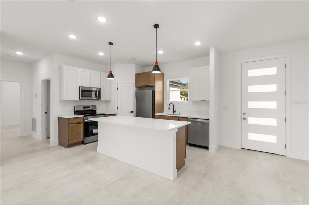 6168 Southwest 154th Street Ocala, FL 34473 - Photo 2 of 33 a kitchen with kitchen island white cabinets and stainless steel appliances