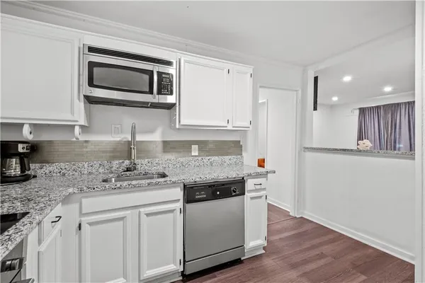 a kitchen with stainless steel appliances granite countertop a sink and a stove