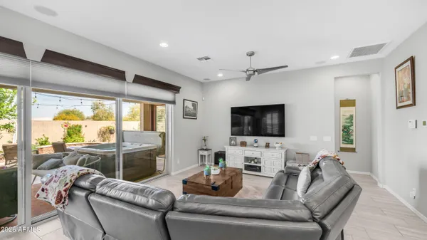 a living room with furniture a flat screen tv and a large window