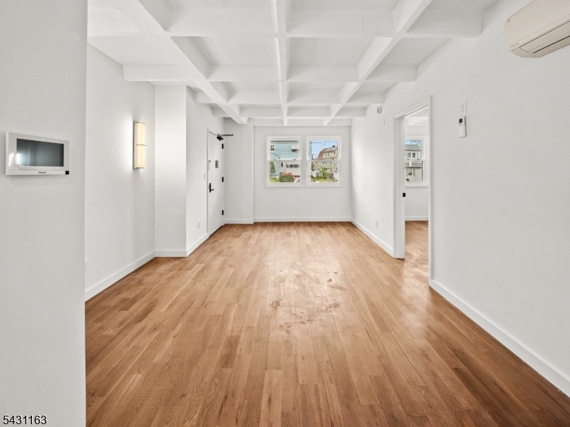 100 Chestnut Street, Unit 3 West Orange, NJ 07052 - Photo 4 of 18 an empty room with wooden floor and windows