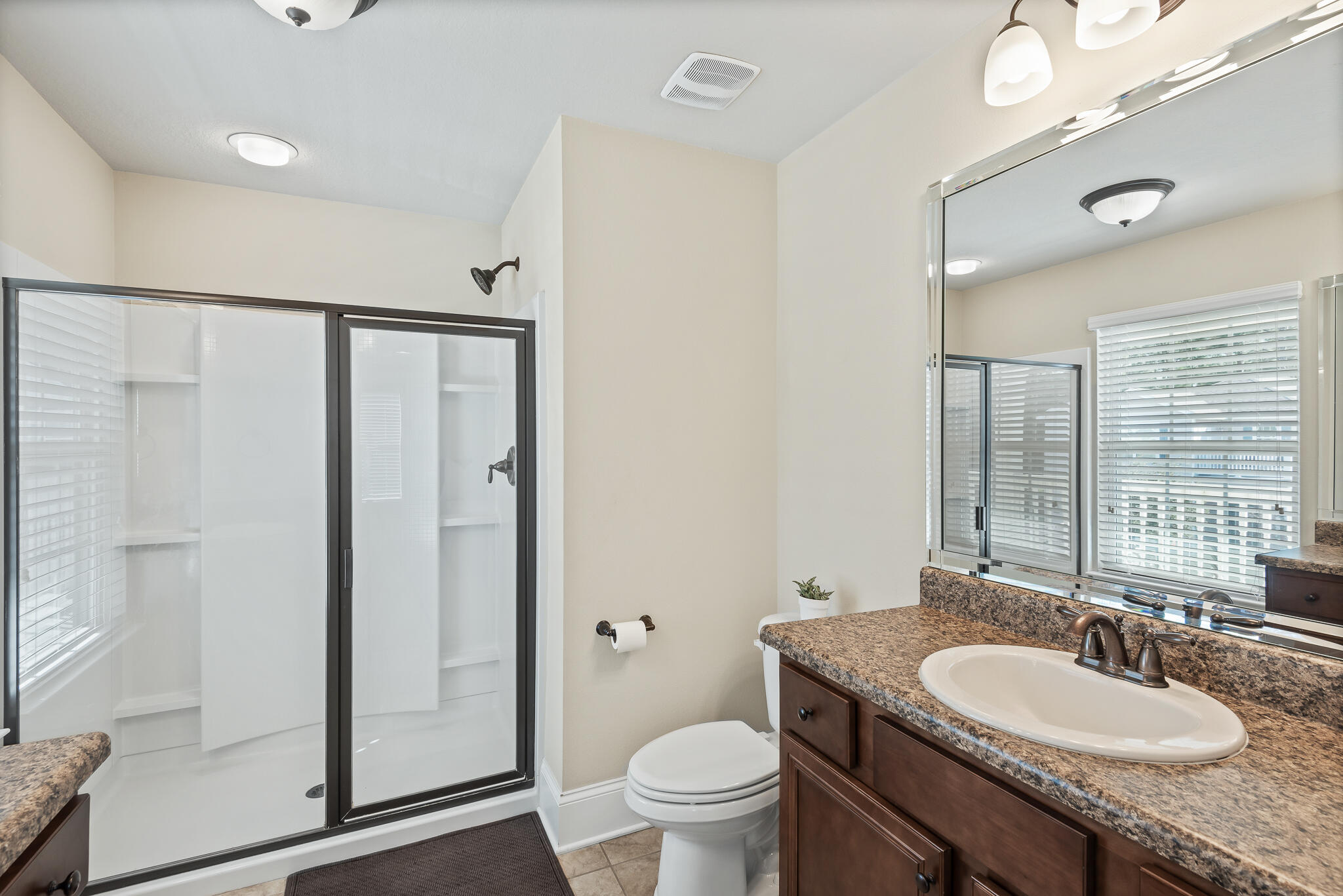 107 Mosaic Oaks Circle Santa Rosa Beach, FL 32459 - Photo 32 of 46 a bathroom with a granite countertop sink toilet a mirror and shower