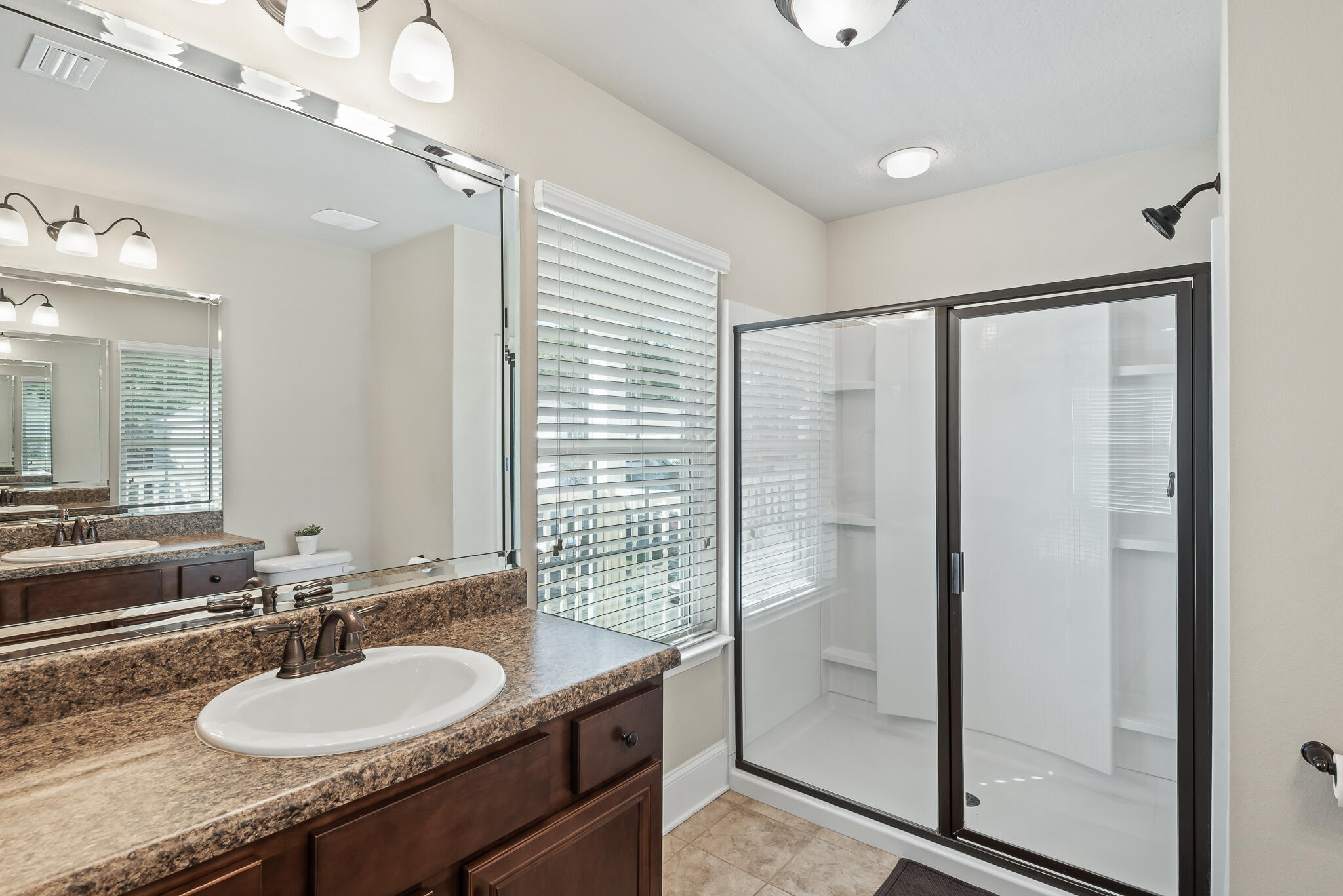 107 Mosaic Oaks Circle Santa Rosa Beach, FL 32459 - Photo 33 of 46 a bathroom with a granite countertop sink a mirror and a shower
